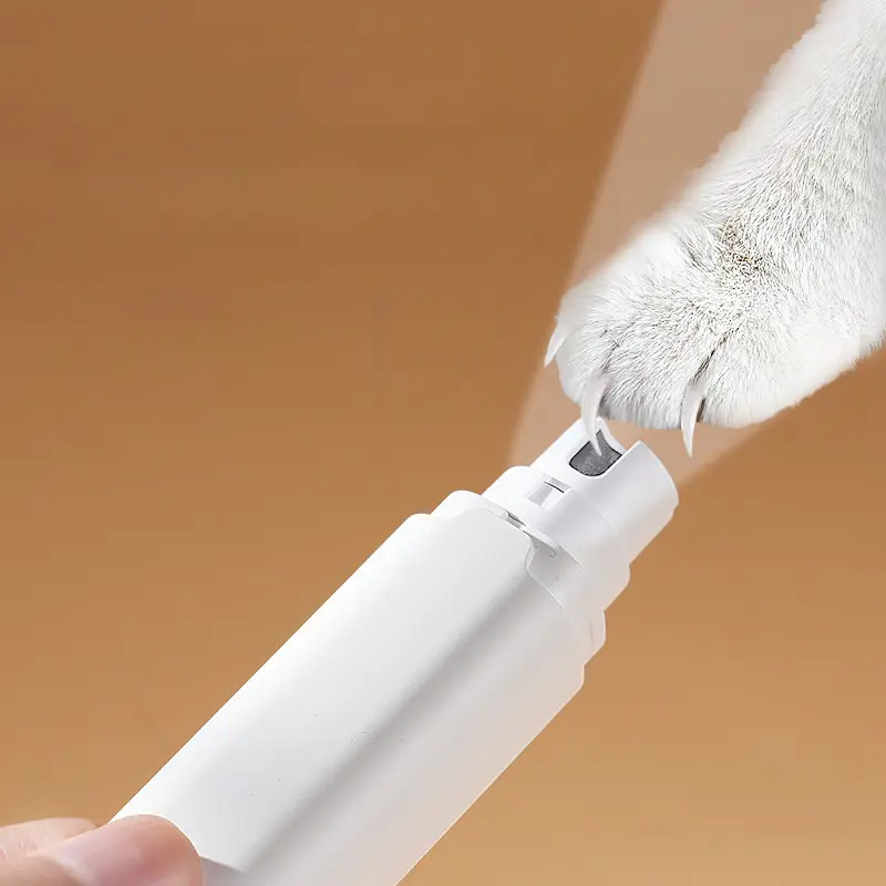 Electric pet nail grinder being used to trim a cat’s claw in a close-up view.